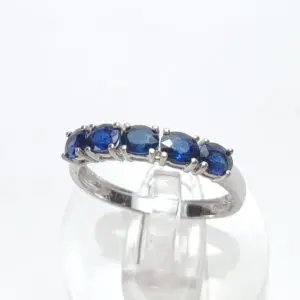 Silver ring with blue gemstones on display.