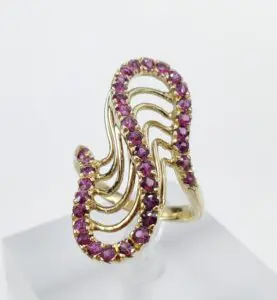 Gold ring with purple gemstones in swirl design.