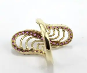 Gold ring with pink gemstones, intricate design.