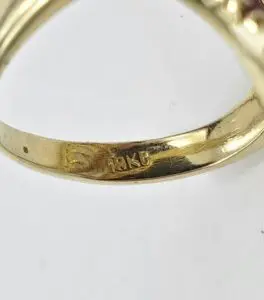 Gold ring with "18K" engraving inside band.