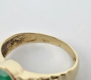 Gold ring with green gemstone, close-up.