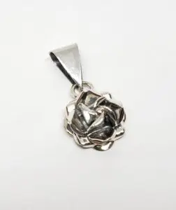 Silver rose pendant on white background.