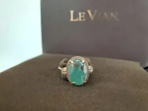 Green gemstone ring on display stand.