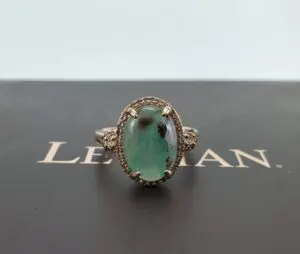 Emerald ring on black surface background.
