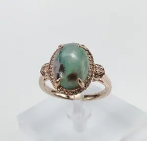 Gold ring with large green gemstone.