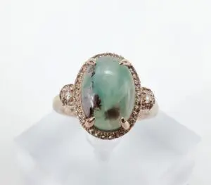 Gold ring with green oval gemstone.