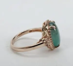 Gold ring with green gemstone and diamonds.
