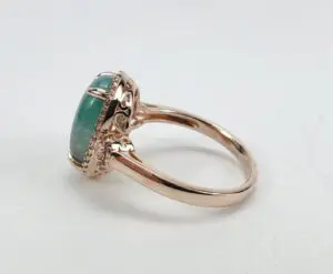 Rose gold ring with green gemstone.