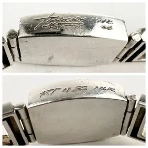 Silver bracelet with engraved markings.