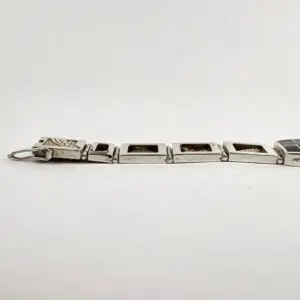 Silver bracelet with rectangular dark inlays.