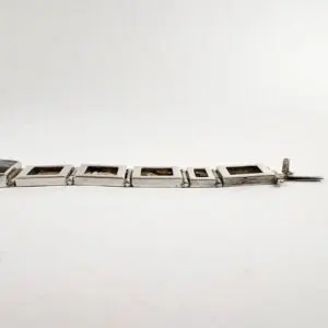 Silver bracelet with square links displayed.