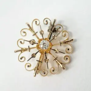 Ornate vintage brooch with central gemstone.