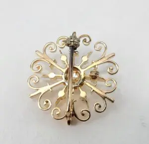 Gold ornate brooch with intricate design.