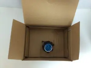 Small item inside large open cardboard box.