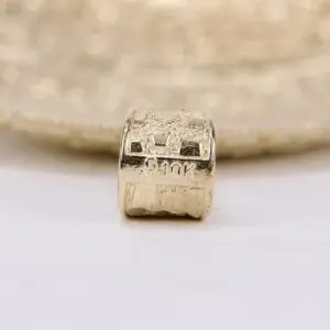Gold bead with engraved "G10K" marking.