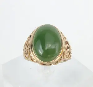 Gold ring with large green gemstone.