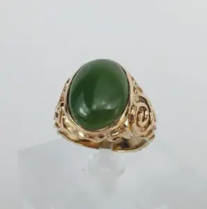 Gold ring with green gemstone centerpiece.
