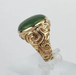 Gold ring with green stone setting.