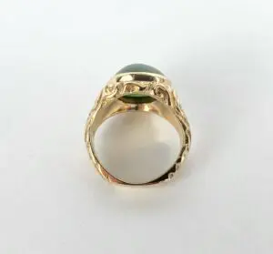 Gold ring with green gemstone and engravings.