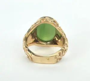 Gold ring with green gemstone, close-up.