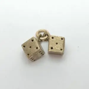 Two brass dice charms on ring.