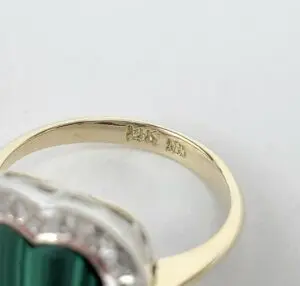 Gold ring with engraved markings inside band.