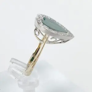 Teardrop gemstone ring with ornate band design.