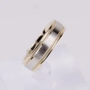 Silver and gold wedding band on display.
