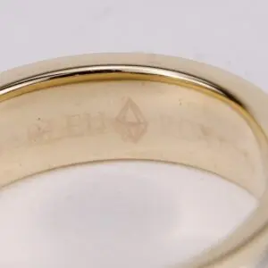 Gold ring with engraved text inside.
