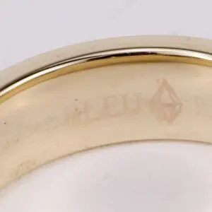 Gold ring with engraved text inside band.