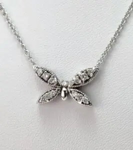 Butterfly-shaped diamond pendant on silver chain.