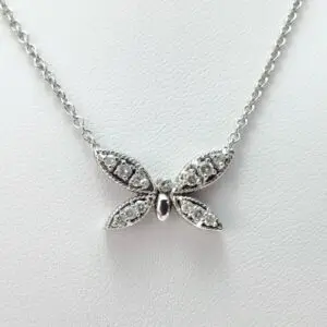 Silver butterfly pendant necklace on white background.