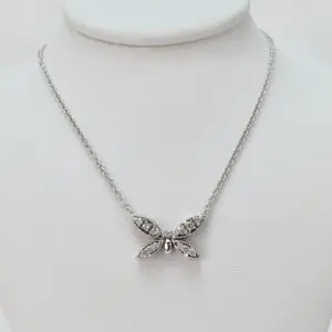 Silver butterfly necklace on display stand.