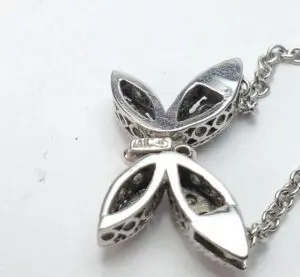 Silver butterfly pendant with intricate design.