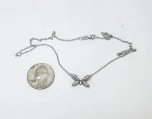 Necklace with butterfly pendant and coin.