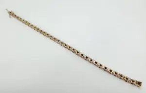 Gold bracelet with red gemstone accents.