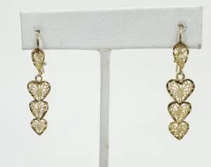 Gold heart-shaped dangling earrings on display.