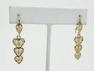 Gold heart-shaped dangle earrings on display.