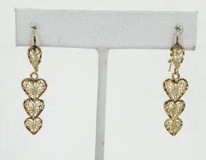 Gold heart-shaped dangle earrings on display.