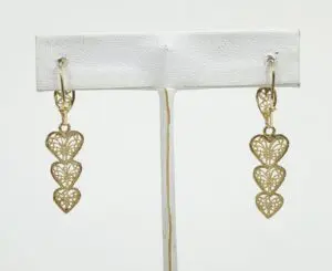 Gold heart-shaped dangle earrings on display.