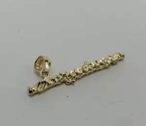Gold flute pendant with decorative details.