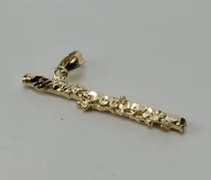 Gold flute pendant on a white background.