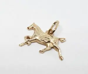 Gold horse pendant on white background.