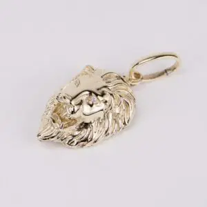Gold lion head pendant on white background.