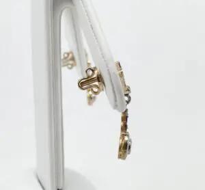 Gold jewelry displayed on white stand.