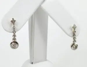 Silver drop earrings with diamond accents displayed.
