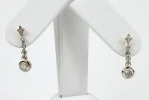 Silver earrings with diamond accents on display.