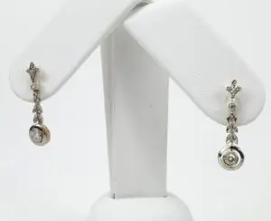 Elegant silver and gold dangling earrings displayed.