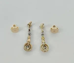 Gold earrings with arrow design and stones.
