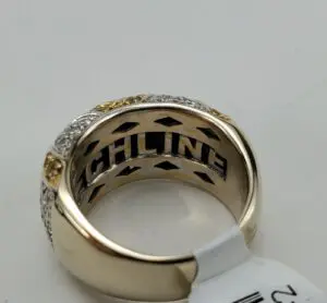 Gold and silver ring with engraved text.